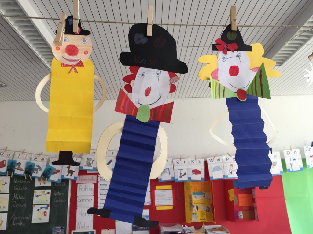 Foto, auf dem gebastelte Clowns an der Decke hängen