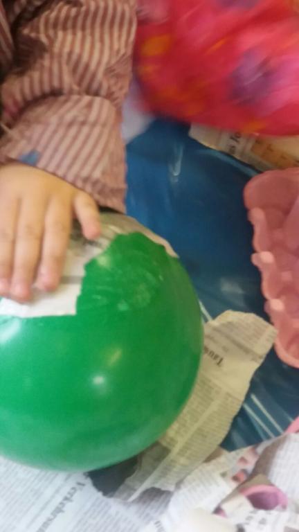 Foto: Kinder bekleben Luftballons mit Kleister und Papier