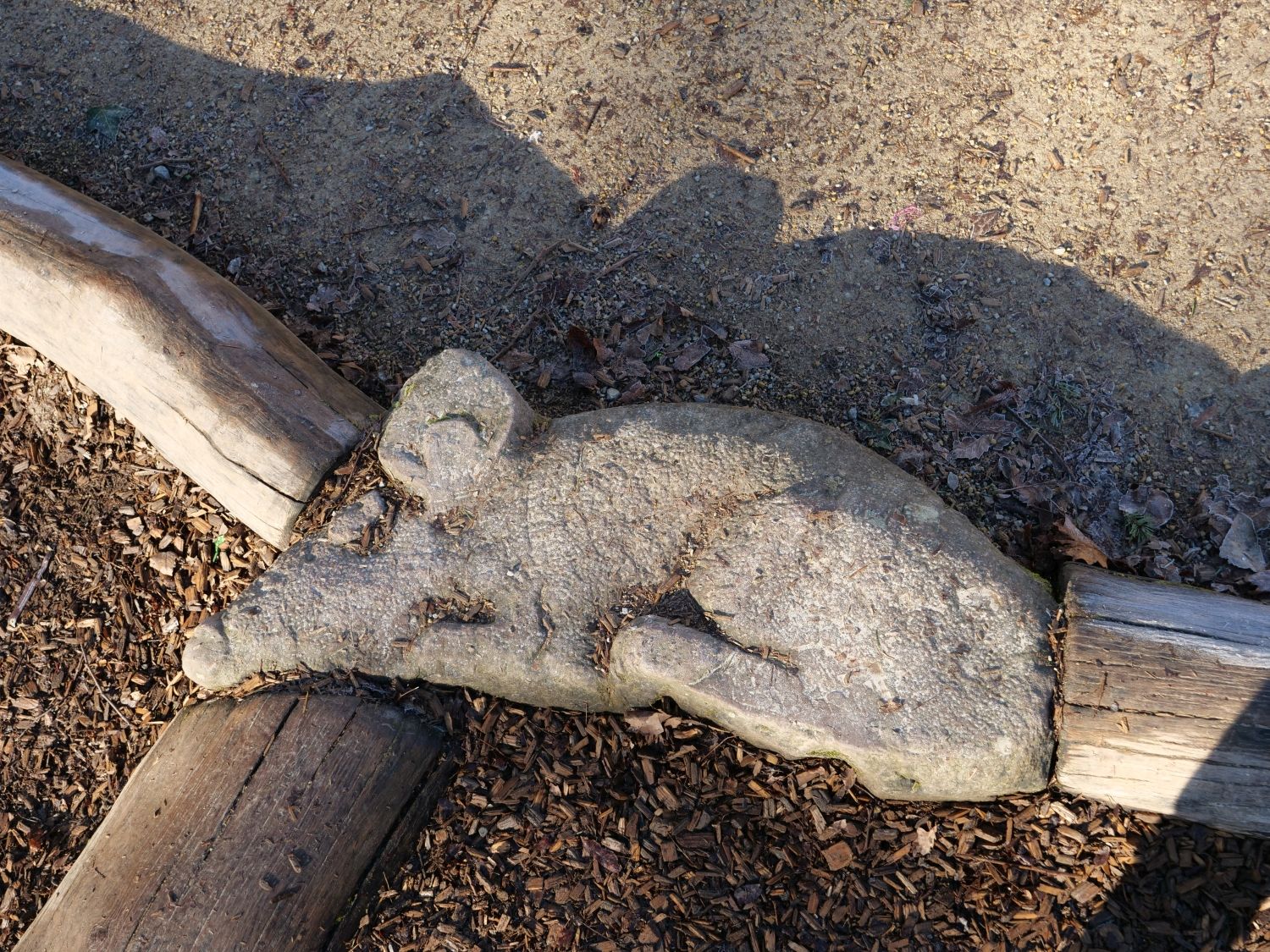 Liegende Steinmaus auf dem Spielplatz